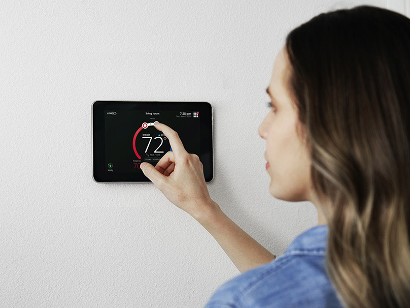 Woman adjusting a thermostat